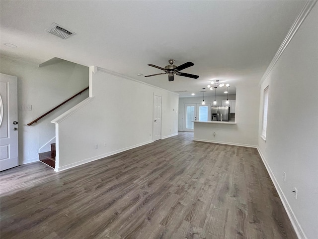 unfurnished living room featuring visible vents, a ceiling fan, crown molding, and dark wood-style floors