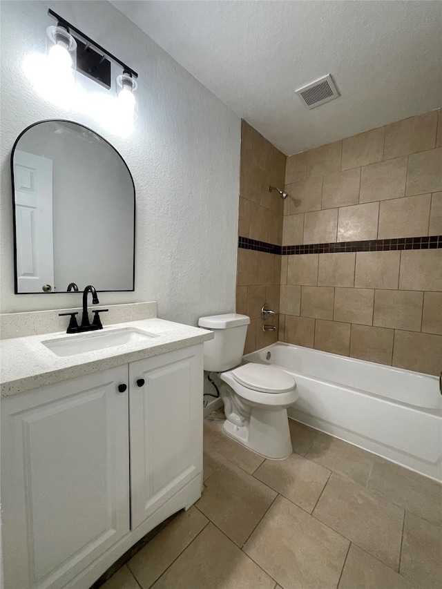full bathroom with visible vents, toilet, a textured wall, shower / bath combination, and vanity