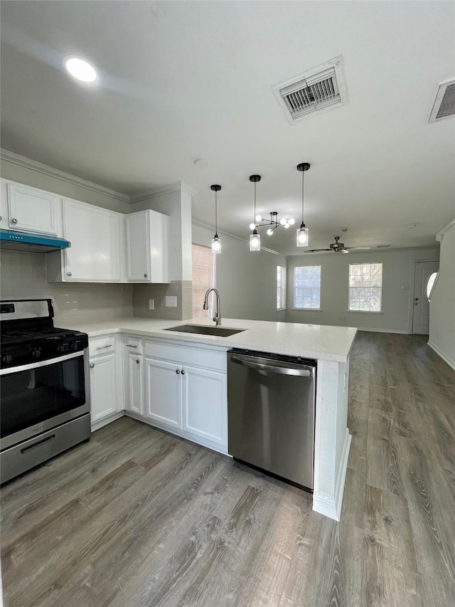 kitchen featuring a peninsula, visible vents, light countertops, a sink, and stainless steel appliances