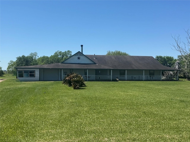 back of property featuring an attached garage and a lawn