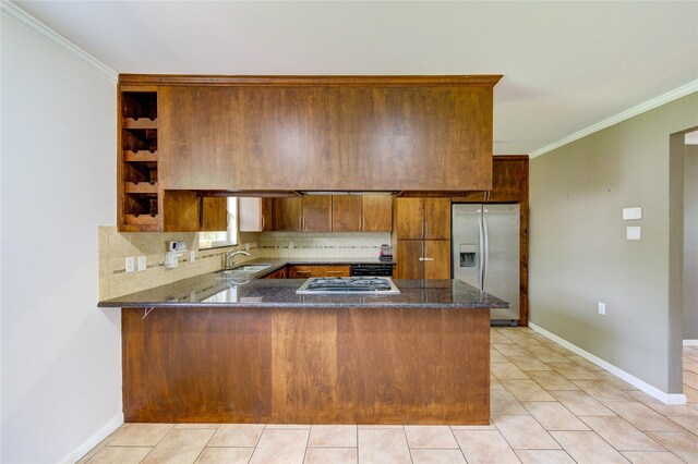 9534 Meadowglen Ln, Houston, TX 77063 - kitchen featuring a sink, a peninsula, brown cabinetry, dark stone counters, and stainless steel appliances