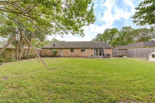 9534 Meadowglen Ln, Houston, TX 77063 - back of house featuring french doors, a fenced backyard, and a lawn