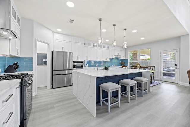 18023 Channel Hill Dr, Cypress, TX 77433 - kitchen with appliances with stainless steel finishes, wall chimney range hood, recessed lighting, a breakfast bar, and tasteful backsplash
