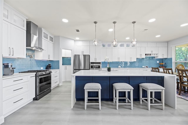 18023 Channel Hill Dr, Cypress, TX 77433 - kitchen with wall chimney exhaust hood, appliances with stainless steel finishes, tasteful backsplash, light countertops, and a spacious island