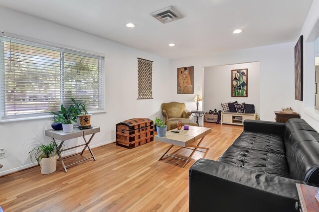 living room with light wood finished floors, recessed lighting, and baseboards