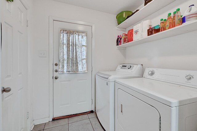 washroom featuring washing machine and dryer and light tile patterned floors