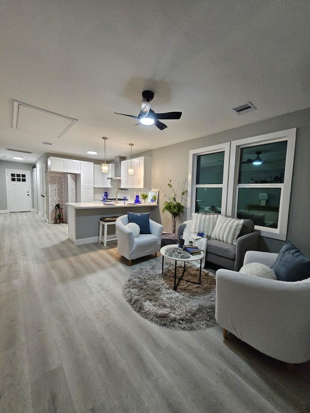 3241 Reeves St, Houston, TX 77004 - living room featuring light wood-style floors, attic access, a ceiling fan, and baseboards