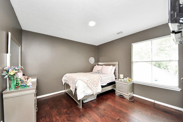 bedroom with baseboards, wood finished floors, and recessed lighting
