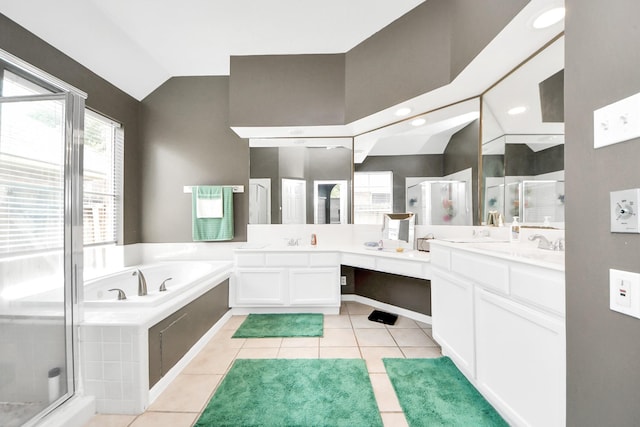 bathroom featuring vaulted ceiling, a shower stall, a garden tub, tile patterned flooring, and double vanity