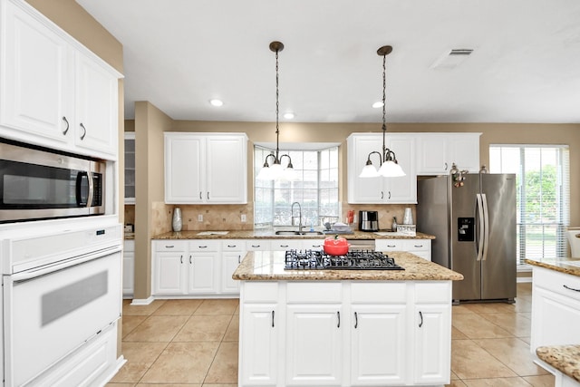 kitchen with stainless steel appliances, a sink, light tile patterned floors, healthy amount of natural light, and recessed lighting