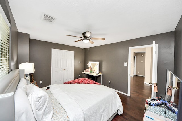 bedroom with dark wood-style floors, a closet, ceiling fan, and baseboards