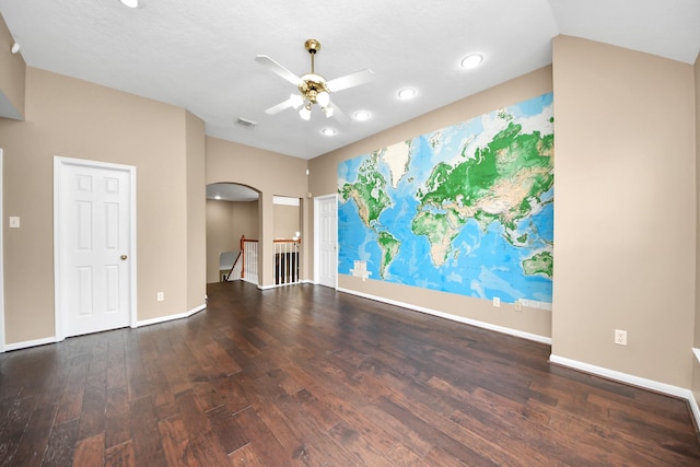 unfurnished living room featuring a ceiling fan, arched walkways, wood finished floors, baseboards, and recessed lighting