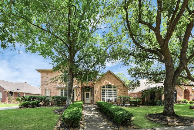 traditional-style home with brick siding and a front yard