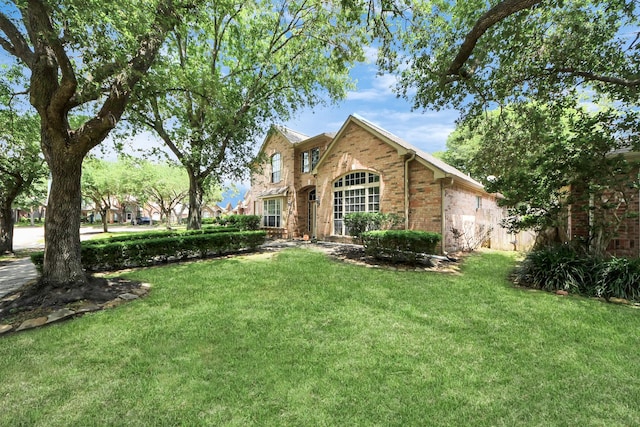 view of front of home with brick siding and a front lawn