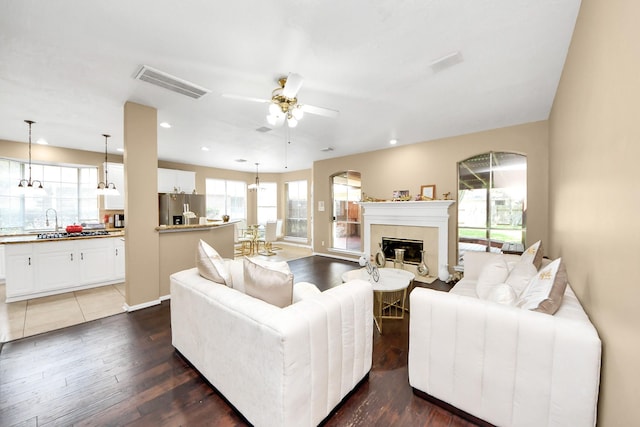 living area featuring ceiling fan, dark wood-type flooring, a tile fireplace, and recessed lighting
