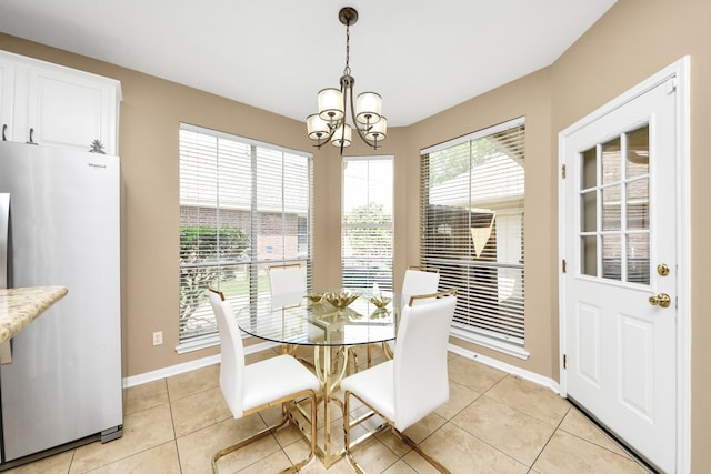 dining room featuring a chandelier, light tile patterned floors, and baseboards