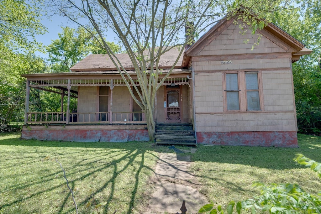 view of front facade with covered porch and a front yard