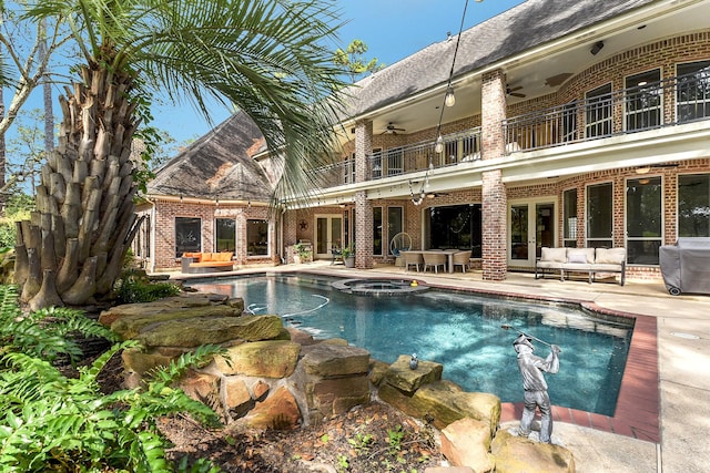view of swimming pool with a pool with connected hot tub, outdoor lounge area, a ceiling fan, a patio, and french doors