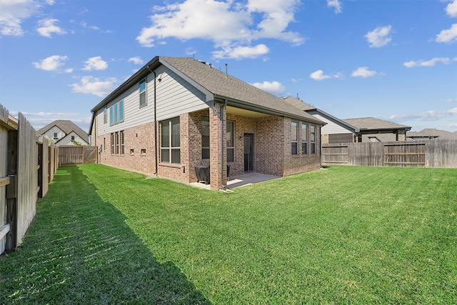908 Newport Creek Dr, Katy, TX 77493 - rear view of property featuring brick siding, a fenced backyard, a lawn, and a patio area