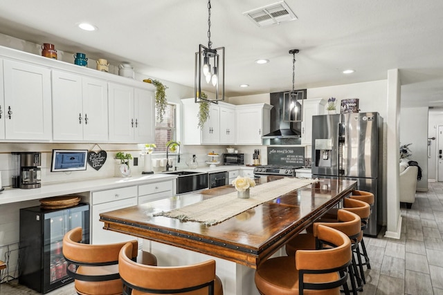 8010 Clover Leaf Dr, Rosenberg, TX 77469 - kitchen with wall chimney range hood, a sink, stainless steel appliances, backsplash, and visible vents