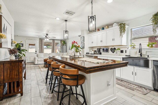 8010 Clover Leaf Dr, Rosenberg, TX 77469 - kitchen with a kitchen breakfast bar, a sink, open floor plan, visible vents, and a kitchen island