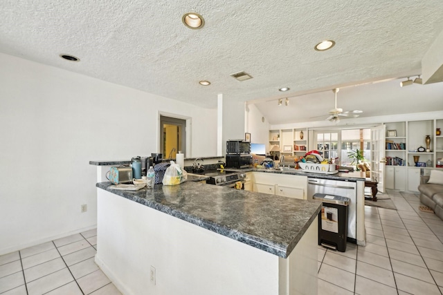 5347 Inwood Dr, Katy, TX 77493 - kitchen with visible vents, light tile patterned floors, ceiling fan, a peninsula, and stainless steel electric range