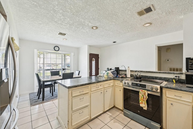 5347 Inwood Dr, Katy, TX 77493 - kitchen with visible vents, light tile patterned floors, dark countertops, appliances with stainless steel finishes, and cream cabinetry