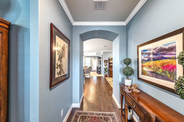 hallway featuring ornamental molding, visible vents, arched walkways, and dark wood-style flooring