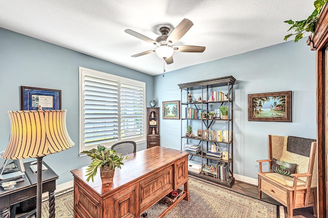 office space featuring ceiling fan, baseboards, and a textured ceiling