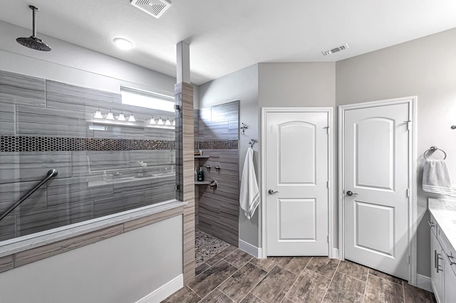 full bathroom with wood tiled floor, vanity, visible vents, and walk in shower