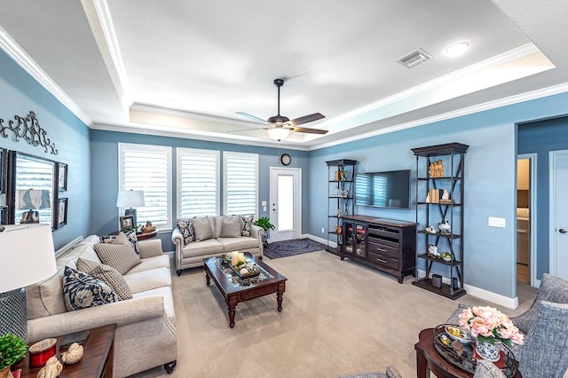 living area featuring a tray ceiling, carpet flooring, ceiling fan, and visible vents