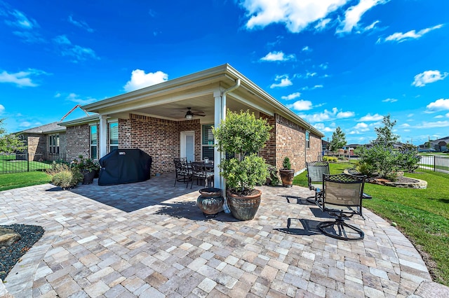 view of patio / terrace with area for grilling, outdoor dining space, fence, and a ceiling fan