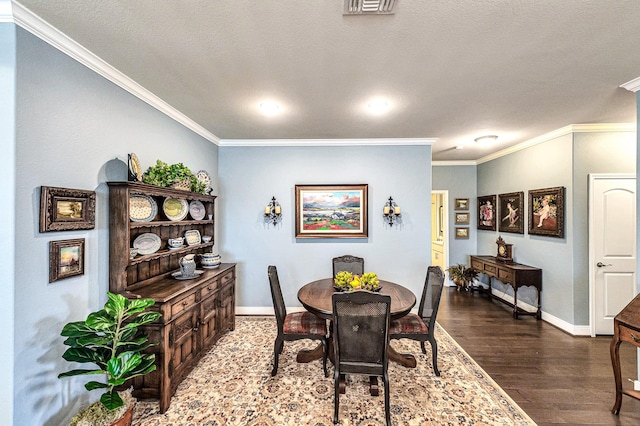 dining space featuring baseboards, ornamental molding, and wood finished floors