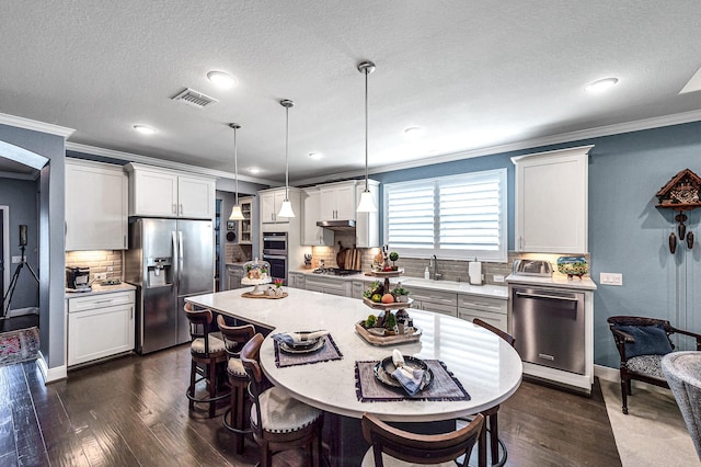 kitchen with a kitchen bar, light countertops, dark wood-style floors, and stainless steel appliances