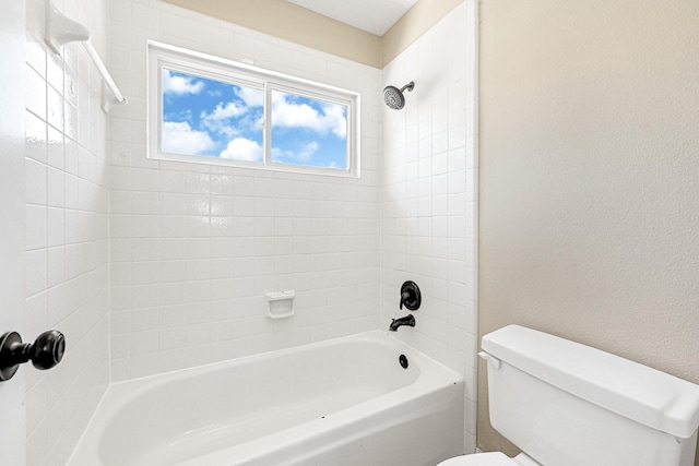 full bath with a textured wall, toilet, and shower / washtub combination