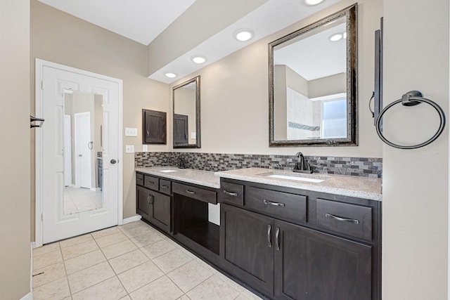 full bathroom with double vanity, a sink, and backsplash