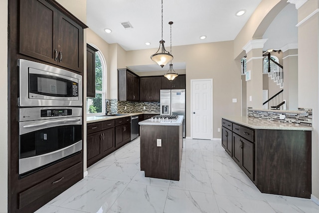 kitchen featuring decorative columns, visible vents, a center island, marble finish floor, and stainless steel appliances
