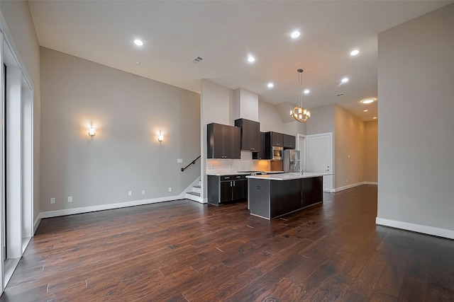 1305 Laird St, Houston, TX 77008 - kitchen featuring light countertops, a chandelier, a center island with sink, dark wood-type flooring, and baseboards