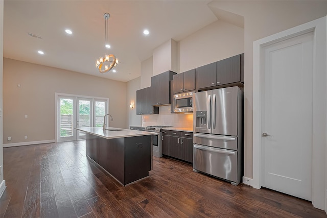 1305 Laird St, Houston, TX 77008 - kitchen featuring appliances with stainless steel finishes, light countertops, a sink, a chandelier, and dark wood-style flooring