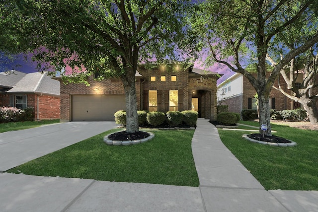 view of front of home featuring driveway, a garage, a front lawn, and brick siding
