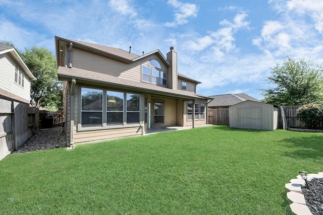 back of property featuring a chimney, a shed, a fenced backyard, an outbuilding, and a lawn