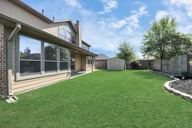 view of yard featuring a fenced backyard, a storage shed, and an outbuilding