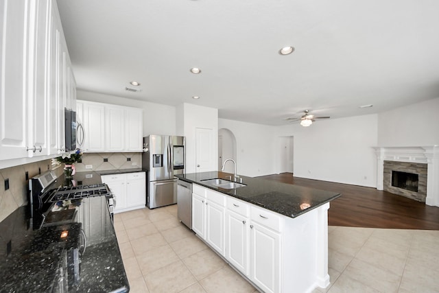 kitchen featuring ceiling fan, light tile patterned floors, tasteful backsplash, a sink, and stainless steel appliances