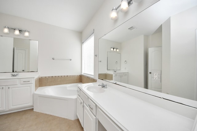 bathroom with a garden tub, two vanities, visible vents, a sink, and tile patterned floors