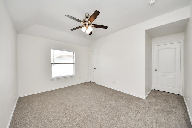 spare room with ceiling fan, carpet, baseboards, and lofted ceiling