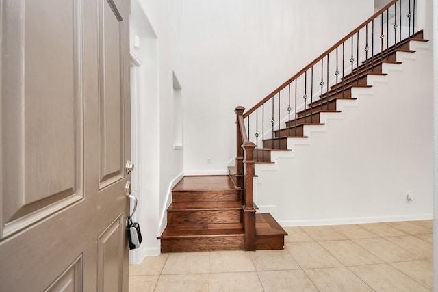 stairway featuring baseboards and tile patterned flooring