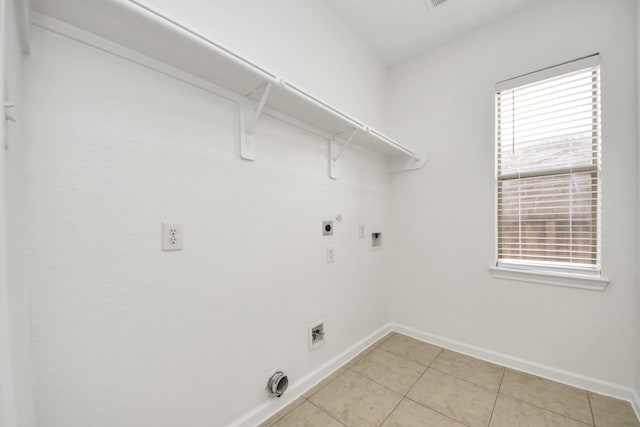 clothes washing area with light tile patterned floors, baseboards, laundry area, gas dryer hookup, and electric dryer hookup