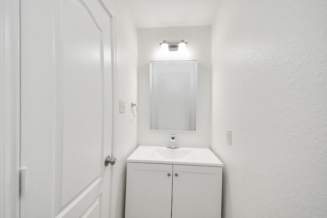 bathroom featuring vanity and a textured wall