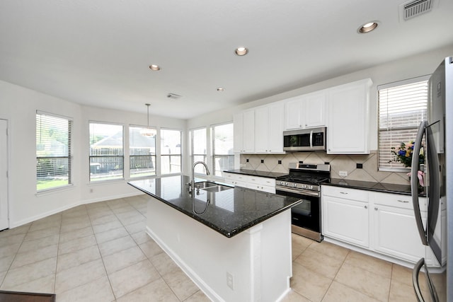kitchen with white cabinetry, visible vents, a sink, stainless steel appliances, and decorative backsplash