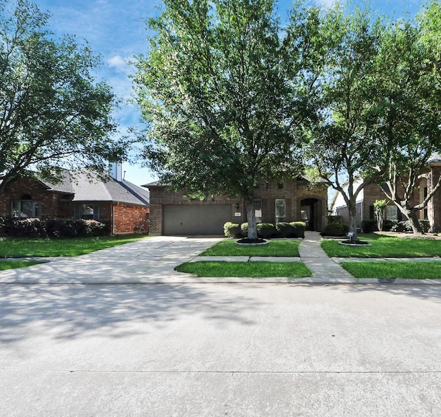 view of front of property featuring driveway, a garage, a front lawn, and brick siding